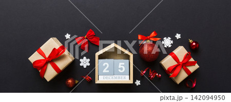 Christmas calendar 25 december. Christmas gift, fir branches, pine cones. Flat lay, top view. New Year decorations on a colored background 142094950