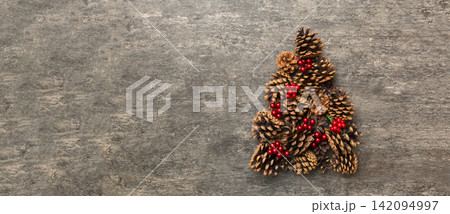 Christmas tree made from natural cones on colored background, view from above. New Year minimal concept with copy space Christmas tree made from natural cones on colored background, view from above. New Year minimal concept with copy space 142094997
