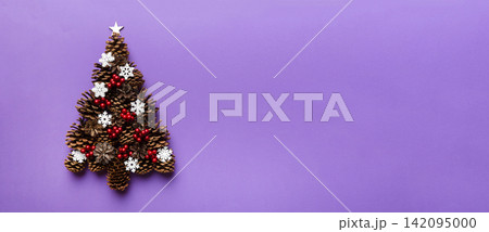 Christmas tree made from natural cones on colored background, view from above. New Year minimal concept with copy space Christmas tree made from natural cones on colored background, view from above. New Year minimal concept with copy space 142095000