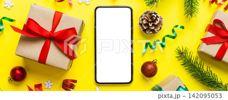 Digital phone mock up with rustic Christmas decorations for app presentation top view with empty space for you design. Christmas online shopping concept. Tablet with copy space on colored background Digital phone mock up with rustic Christmas decorations for app presentation top view with empty space for you design. Christmas online shopping concept. Tablet with copy space on colored background 142095053