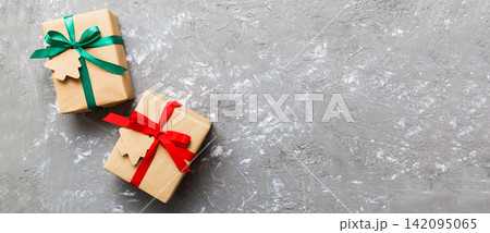 wrapped christmas or other holiday handmade present in paper with colored ribbon. Present box, decoration of gift on colourfull table, top view with copy space wrapped christmas or other holiday handmade present in paper with colored ribbon. Present box, decoration of gift on colourfull table, top view with copy space 142095065