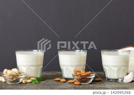 Set or collection of various vegan milk almond, coconut, cashew, on table background. Vegan plant based milk and ingredients, top view 142095268