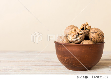 Fresh healthy walnuts in bowl on colored table background. Top view Healthy eating bertholletia concept. Super foods 142095285
