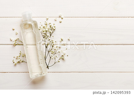 Fancy healthcare bottles for serum, micellar, tonic, toner, lotion, water and cream with gypsophila branch. Natural oranic spa cosmetics concept. Mockup, template, Top view 142095393