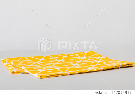 top view with yellow empty kitchen napkin isolated on table background. Folded cloth for mockup with copy space, Flat lay. Minimal style 142095913