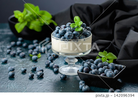 Panna cotta with fresh blueberries in a clear bowl. Panna cotta with fresh blueberries in a clear bowl. 142096394