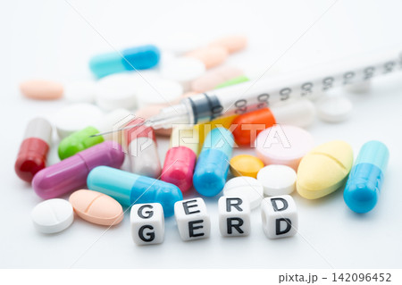 GERD Gastro esophageal Reflux Disease word with pills and capsules medical drug. GERD Gastro esophageal Reflux Disease word with pills and capsules medical drug. 142096452