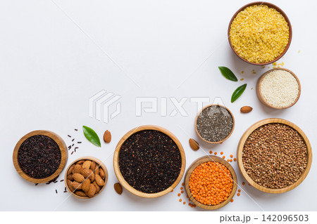 Various superfoods in smal bowl on colored background. Superfood as rice, chia, quinoa, lentils, nuts, sesame seeds, almonds. top view copy space Various superfoods in smal bowl on colored background. Superfood as rice, chia, quinoa, lentils, nuts, sesame seeds, almonds. top view copy space 142096503