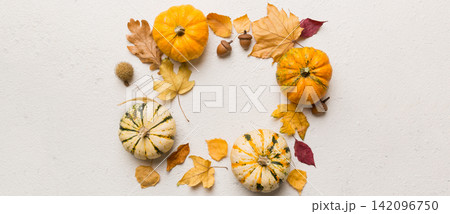 Autumn composition Pumpkins with fall leaves over coloredbackground. Top view with copy space 142096750