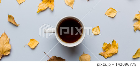 Flat lay composition with colorful Autumn cup of coffee and leaves on a color background. top view 142096779