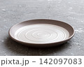 Perspective view of empty light plate on cement background. Empty space for your design 142097083