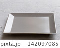 Perspective view of empty square plate on cement background. Empty space for your design 142097085