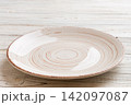 Perspective view of empty light plate on wooden background. Empty space for your design 142097087