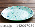Perspective view of empty blue plate on wooden background. Empty space for your design 142097089