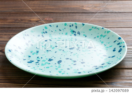 Perspective view of empty blue plate on wooden background. Empty space for your design 142097089