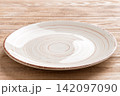 Perspective view of empty colorful plate on wooden background. Empty space for your design 142097090