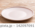 Perspective view of empty light plate on wooden background. Empty space for your design 142097091