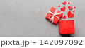 Happy valentines day opened heart shape gift box with small hearts, on colored background, valentines day card - top view concept 142097092