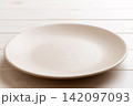 Perspective view of empty light plate on wooden background. Empty space for your design 142097093