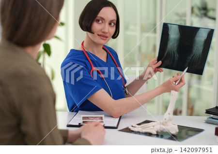 Woman doctor explains foot X-ray picture during clinic visit Woman doctor explains foot X-ray picture during clinic visit 142097951