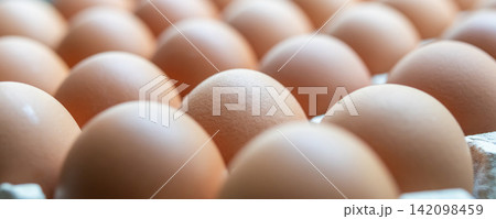 Fresh organic brown chicken eggs in cardboard tray 142098459