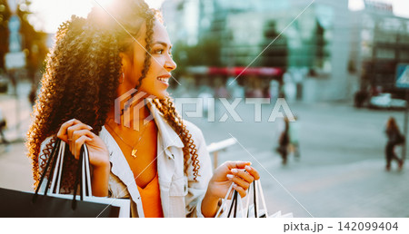 Young woman with shopping bags walking on street. , Sale concept. 142099404