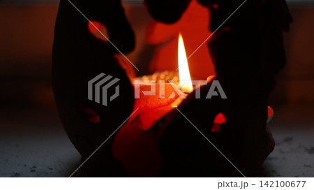 A burning candle in a candlestick. 142100677