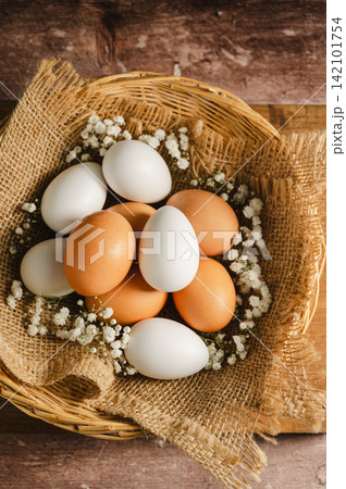 Easter eggs background. White eggs in rustic bowl and gypsophila flowers. Spring holiday Easter eggs background. White eggs in rustic bowl and gypsophila flowers. Spring holiday 142101754