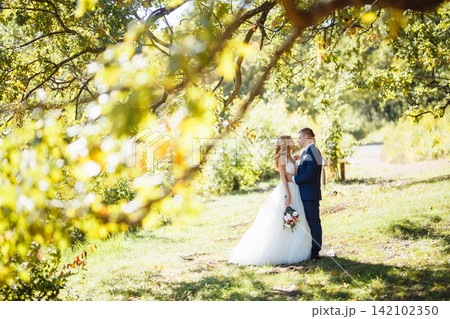 Happy romantic newlyweds are walking in park on their wedding day.Young family. Concept of wedding. Happy romantic newlyweds are walking in park on their wedding day.Young family. Concept of wedding. 142102350