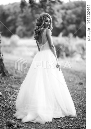Black and white photo of Beautiful bride in white dress for walk in park. Wedding day. Fashion bride Black and white photo of Beautiful bride in white dress for walk in park. Wedding day. Fashion bride 142102462