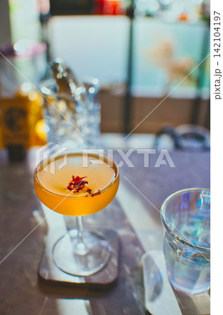 カフェバーのカウンターに置かれた華やかなフラワーカクテル カフェバーのカウンターに置かれた華やかなフラワーカクテル 142104197