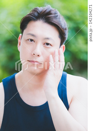 屋外で肌悩みと向き合いフェイスケアをする40代男性のボタニカルスキンケア 屋外で肌悩みと向き合いフェイスケアをする40代男性のボタニカルスキンケア 142104271
