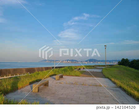 ポートアイランドの海岸沿いにある公園のベンチと街並み ポートアイランドの海岸沿いにある公園のベンチと街並み 142104520