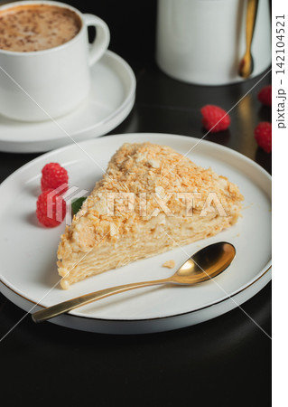 Sliced Napoleon cake on a white wooden table. Classic dessert Sliced Napoleon cake on a white wooden table. Classic dessert 142104521