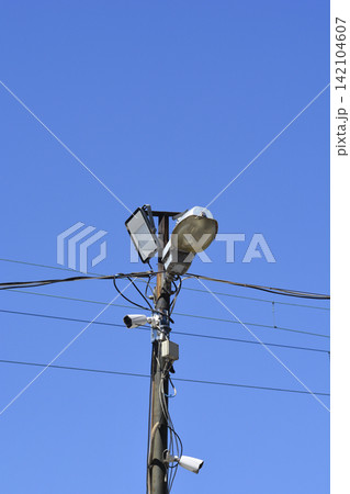 Street light pole with security cameras against blue sky Street light pole with security cameras against blue sky 142104607