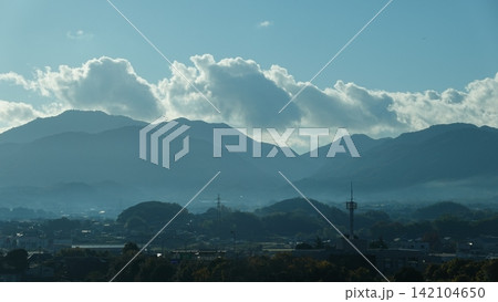 青空と白い雲が広がる山あいの街並み 142104650