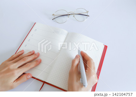手帳に書き込む手元 手帳に書き込む手元 142104757