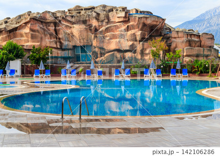 Swimming pool with clear water at a tropical resort Swimming pool with clear water at a tropical resort 142106286
