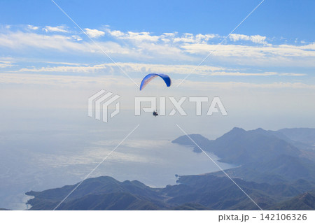 Paragliders flying from a top of Tahtali mountain near Kemer, Antalya Province in Turkey. Concept of active lifestyle and extreme sport adventure 142106326