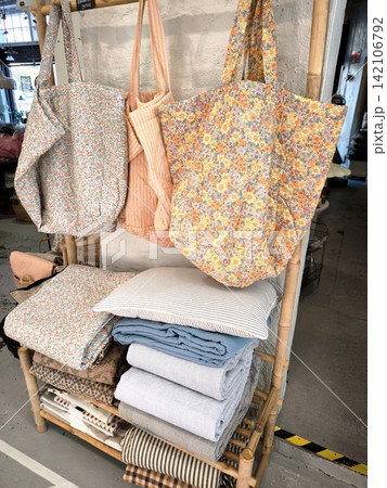 Fabric shopping bags and bedding on a bamboo hanger 142106792