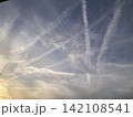 夕暮れの空に交差する飛行機雲と幻想的な雲 142108541