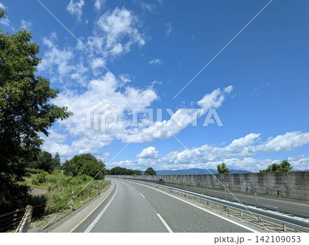 夏の青空と緑の中を走るカーブした高速道路 夏の青空と緑の中を走るカーブした高速道路 142109053