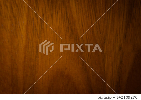 Warm brown wooden surface showing intricate grain patterns, creating a rustic background texture for design and decorative projects Warm brown wooden surface showing intricate grain patterns, creating a rustic background texture for design and decorative projects 142109270