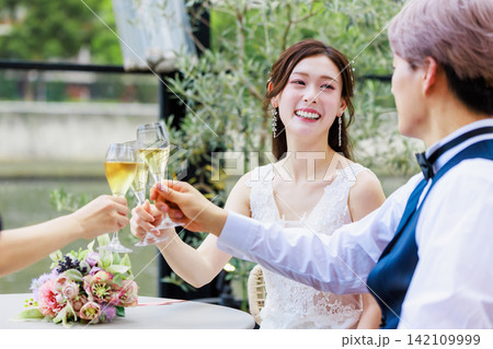 友人とシャンパンを飲む新郎新婦  ウェディングイメージ 142109999