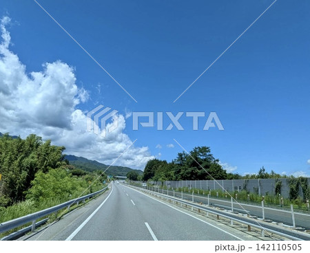 夏の青空と緑の中を走る高速道路 夏の青空と緑の中を走る高速道路 142110505
