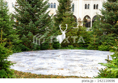 White decorative deer among Christmas trees White decorative deer among Christmas trees 142110696