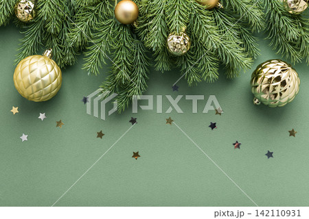 Festive Christmas Ornaments and Pine Needles Scatter Stars on a Subtle Green Background Festive Christmas Ornaments and Pine Needles Scatter Stars on a Subtle Green Background 142110931