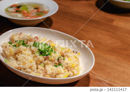 木製テーブルの上のチャーハンとスープ 142111417