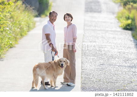 犬の散歩をするシニア夫婦 142111802