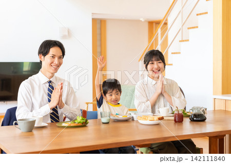 朝食を前に笑顔で手を合わせる3人家族 朝食を前に笑顔で手を合わせる3人家族 142111840